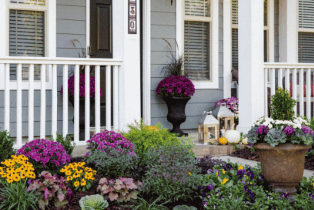 Autumn container garden with mums and pumpkins on a front porch