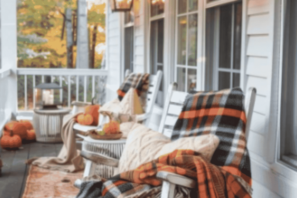 Cozy plaid accents on a fall front porch with pumpkins