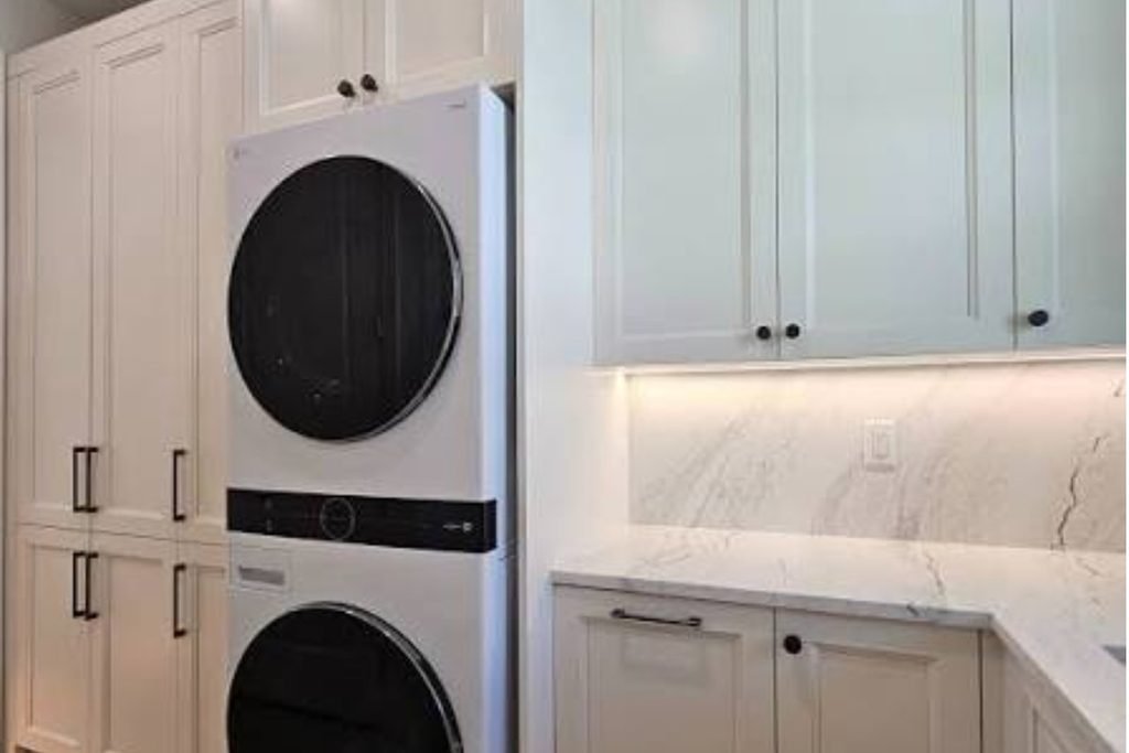 White shaker cabinets around stacked washer and dryer